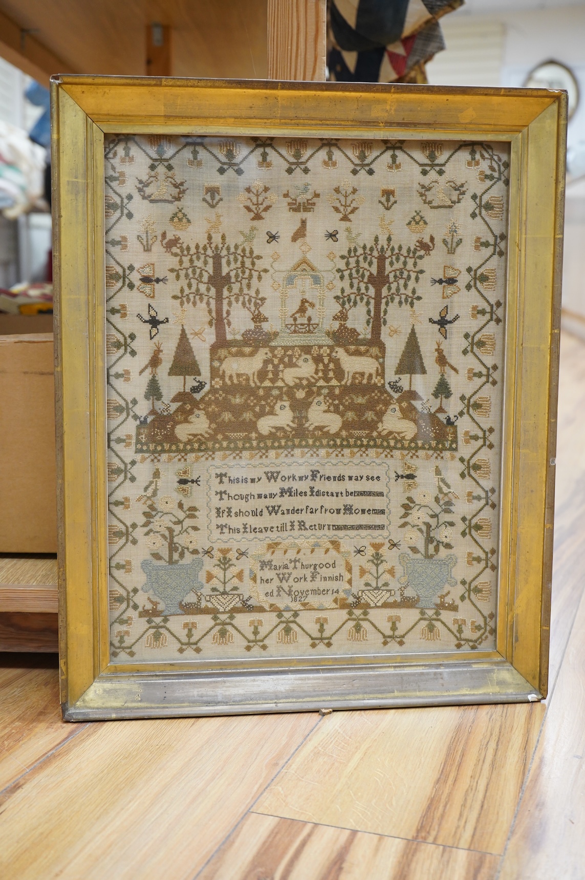 A finely worked sampler by Maria Thurgood, dated 14th November 1827. The sampler packed with finely embroidered motifs, the central motif of a large altar with lambs of God surrounded by motifs of birds, butterflies, rab